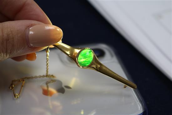 A Chinese yellow metal and jadeite cabochon bar brooch, 62mm.